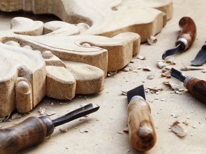 Holzbildhauer Holzschnitzereien und Werkzeuge mit Holzspänen auf Arbeitstisch