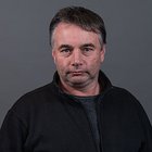 Binder, Drechsler, Wagner Porträt eines Mannes mit dunklem Pullover vor grauem Hintergrund