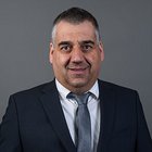 Transport Porträt eines Mannes in Anzug und Krawatte vor grauem Hintergrund