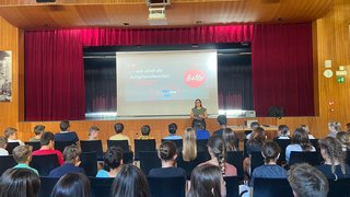 Junghandwerker Jugendliche hören auf einer Bühne einer Präsentation in einem Saal zu