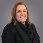 Das lvh-Team Porträt einer lächelnden Frau mit blonden Haaren vor grauem Hintergrund