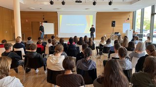 Junghandwerker Schuler sitzen in einem Raum und horchen einer Praesentation zu