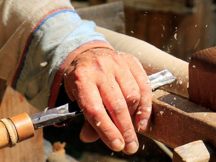 Binder, Drechsler, Wagner Hand eines Handwerkers bearbeitet Holz mit einem Meißel
