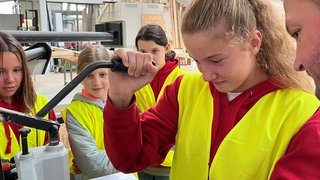 Junghandwerker Jugendliche lernen Holz bearbeiten in einer Werkstatt mit Anleitung