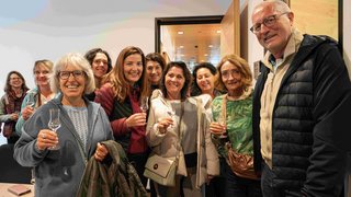 Frauen im Handwerk Gruppe von Erwachsenen, die mit Gläsern anstoßen und lächeln in einem Raum