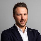 Baugewerbe Porträt eines lächelnden Mannes mit kurzen braunen Haaren und dunklem Anzug