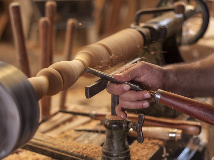 Binder, Drechsler, Wagner Hand eines Tischlers, die Holz an einer Drehmaschine formt