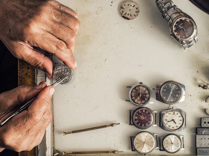 Uhrmacher Uhrmacher repariert alte Uhren mit Werkzeugen auf Werkbank