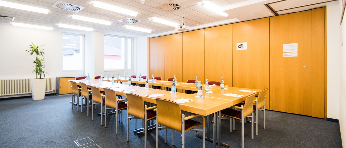 Vermietung Seminarräume Helles Konferenzzimmer mit Tisch, Stühlen und Wasserflaschen vorbereitet