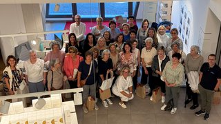 Frauen im Handwerk Große Gruppe von Frauen und Männern, die in einem Raum mit großen Fenstern posieren