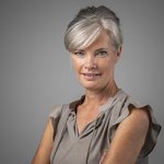 Das lvh-Team Porträt einer lächelnden Frau mit grauen Haaren vor grauem Hintergrund