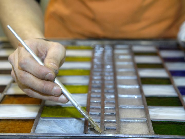 Glaser Hand bemalt Glasfenster mit Pinsel und bunten Glasstücken