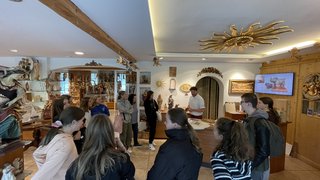 Junghandwerker Gruppe von Jugendlichen bei einer Führung durch einen Holzschnitzerei-Shop