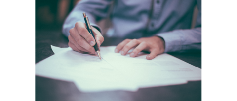 Unternehmensentwicklung Hand schreibt mit Stift auf Papier auf Tisch