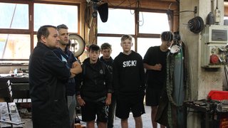 Junghandwerker Gruppe von Jugendlichen und einem Mann in Werkstatt mit Maschinenausrüstung