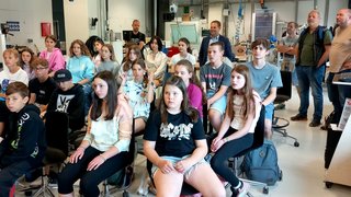 Junghandwerker Schüler und Erwachsene sitzen und stehen in einem modernen Klassenzimmer bei einer Präsentation