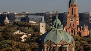 Webinare Stadtansicht mit Kirchen und Hochhäusern unter dem Titel Arbeiten in Deutschland