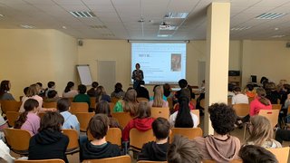 Junghandwerker Lehrerin hält Präsentation vor Schülern in einem Klassenraum