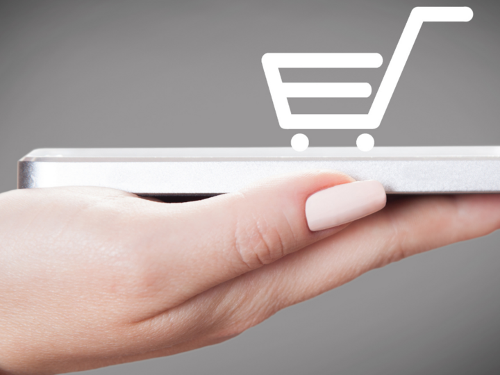 Digitale Lösungen Hand hält Smartphone mit Einkaufswagen-Icon über Bildschirm symbolisiert Online-Shopping