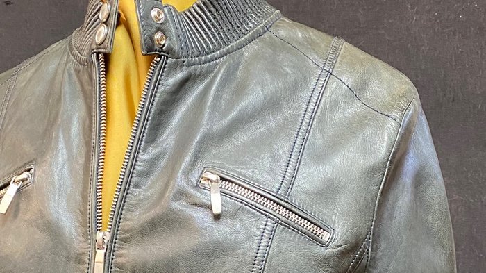 Kürschner Detailaufnahme einer grauen Lederjacke mit Reißverschlusstaschen