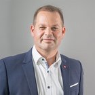 Nachhaltiges Handwerk Porträt eines Mannes in Anzug vor grauem Hintergrund