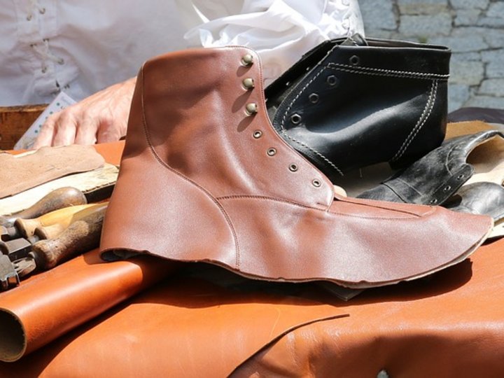 Schuhmacher Handgefertigter brauner Lederschuh neben Werkzeug und schwarzem Schuh