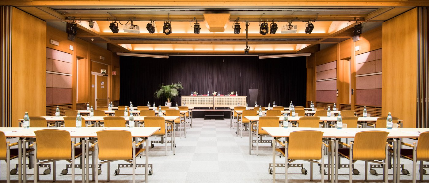 Vermietung Seminarräume Leerer Konferenzraum mit Tischen, Stühlen und Flaschen auf jedem Tisch