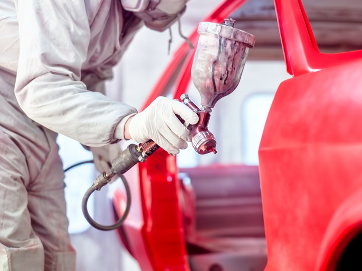 Karosserietechniker Person lackiert roten Autotür mit Spritzpistole