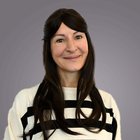 Baumeister und Maurer Porträt einer lächelnden Frau mit schwarzen langen Haaren und gestreiftem Pullover