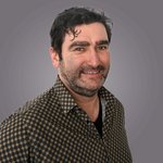 Das lvh-Team Porträt eines lächelnden Mannes mit dunklem Hemd vor grauem Hintergrund