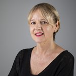 Das lvh-Team Porträt einer Frau mit kurzem blonden Haar und rotem Lippenstift vor grauem Hintergrund