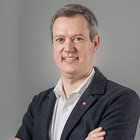 Gebäudetechnik Porträt eines Mannes mit verschränkten Armen vor grauem Hintergrund