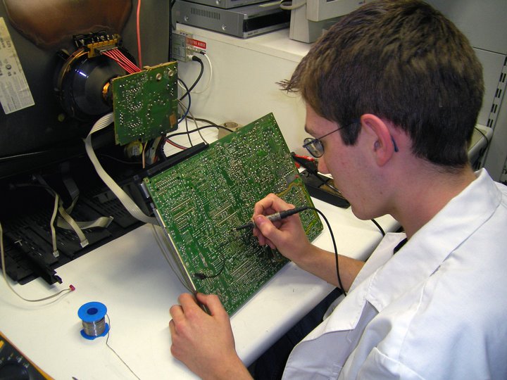 Kommunikationstechniker Techniker überprüft Leiterplatte mit Messgerät in Laborumgebung