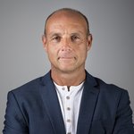 Das lvh-Team Porträt eines mittelalten Mannes in weißem Hemd und blauem Sakko vor grauem Hintergrund