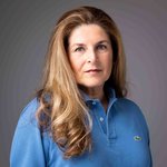 Das lvh-Team Porträt einer Frau mit langem blonden Haar und blauem Poloshirt vor grauem Hintergrund