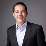 Das lvh-Team Lächelnder Mann in schwarzem Anzug vor grauem Hintergrund