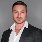 Steuerberatung, Buchhaltung und Lohnabrechnung Porträt eines Mannes mit blauem Blick in weißem Hemd und schwarzem Sakko vor grauem Hintergrund