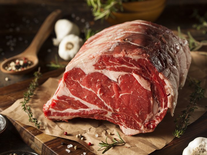 Metzger Frisches Rinderfilet auf Holzbrett mit Gewürzen und Knoblauch