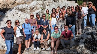 Frauen im Handwerk Gruppenfoto von 27 Personen vor einer Felswand bei sonnigem Wetter