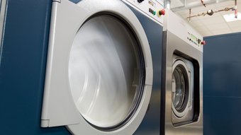 Textilreiniger Industriewaschmaschinen in Betrieb mit Sicht auf die rotierenden Trommeln