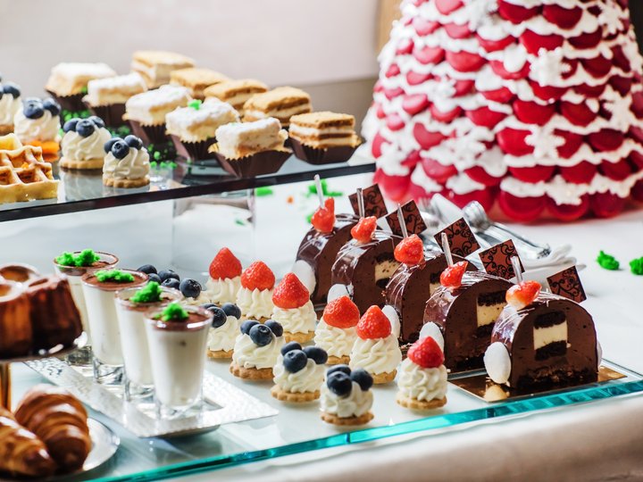 Konditoren Verschiedene Dessertportionen mit Sahne, Erdbeeren und Schokolade auf einem Tisch