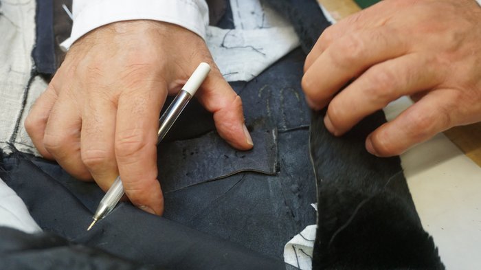 Kürschner Hände eines Schneiders prüfen und markieren Stoff für eine Naht