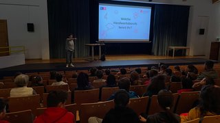 Junghandwerker Vortrag über handwerkliche Berufe vor einem Publikum in einem Saal