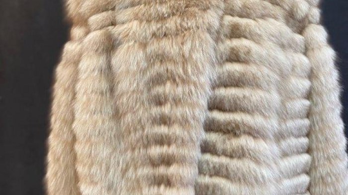 Kürschner Beiger Pelzmantel auf Büste vor dunklem Hintergrund