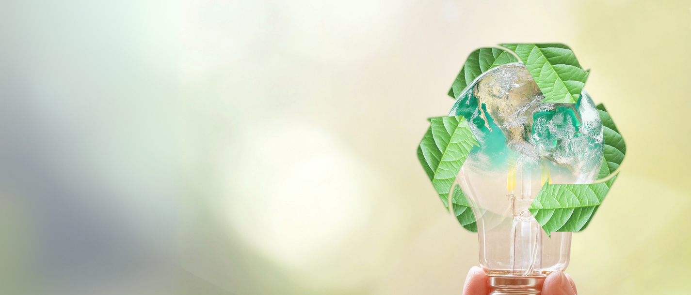 Umweltrecht Hand hält Glühbirne mit Erde und Recycling-Symbol aus grünen Blättern