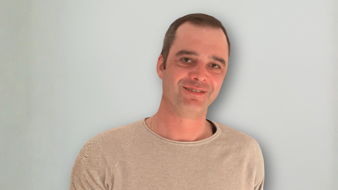 Home Mann mit beigem Pullover vor hellem Hintergrund