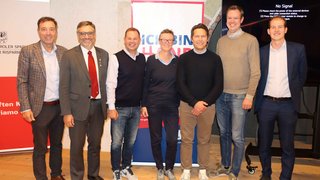 News Sette persone in piedi davanti a due rollup banner e a uno schermo