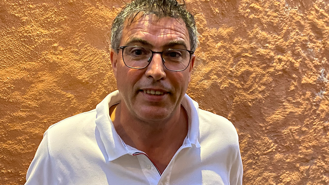 Home Mann mit Brille und weißem Poloshirt vor strukturierter Wand