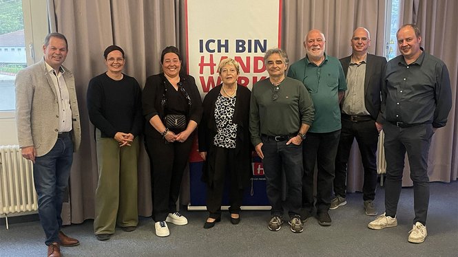 Home Acht Personen stehen vor einem Banner mit dem Text Ich bin Handwerk