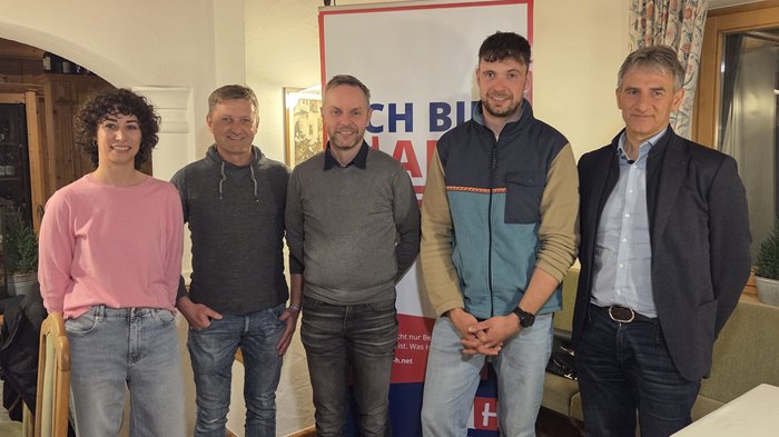 Handwerk hautnah erleben: Schülerinnen und Schüler erkunden vielfältige Berufe und Betriebe im Eggental Fünf Personen stehen vor Banner in Zimmer bei Veranstaltung